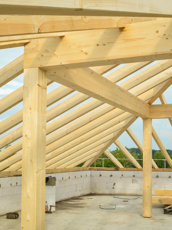 Dachstuhl aus hellem Bauholz über einem Rohbau